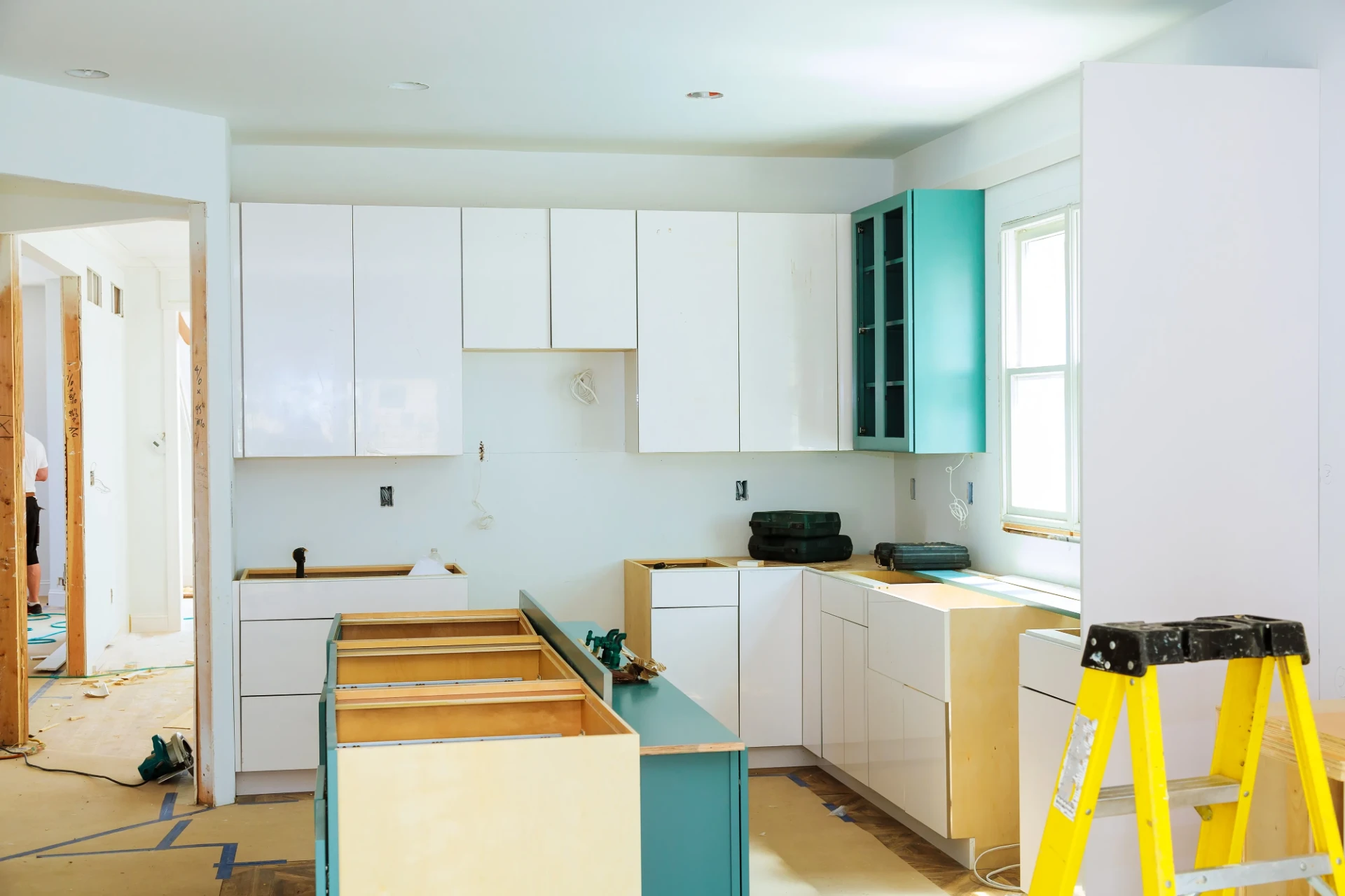 Köksrenovering med nya vita köksluckor under montering